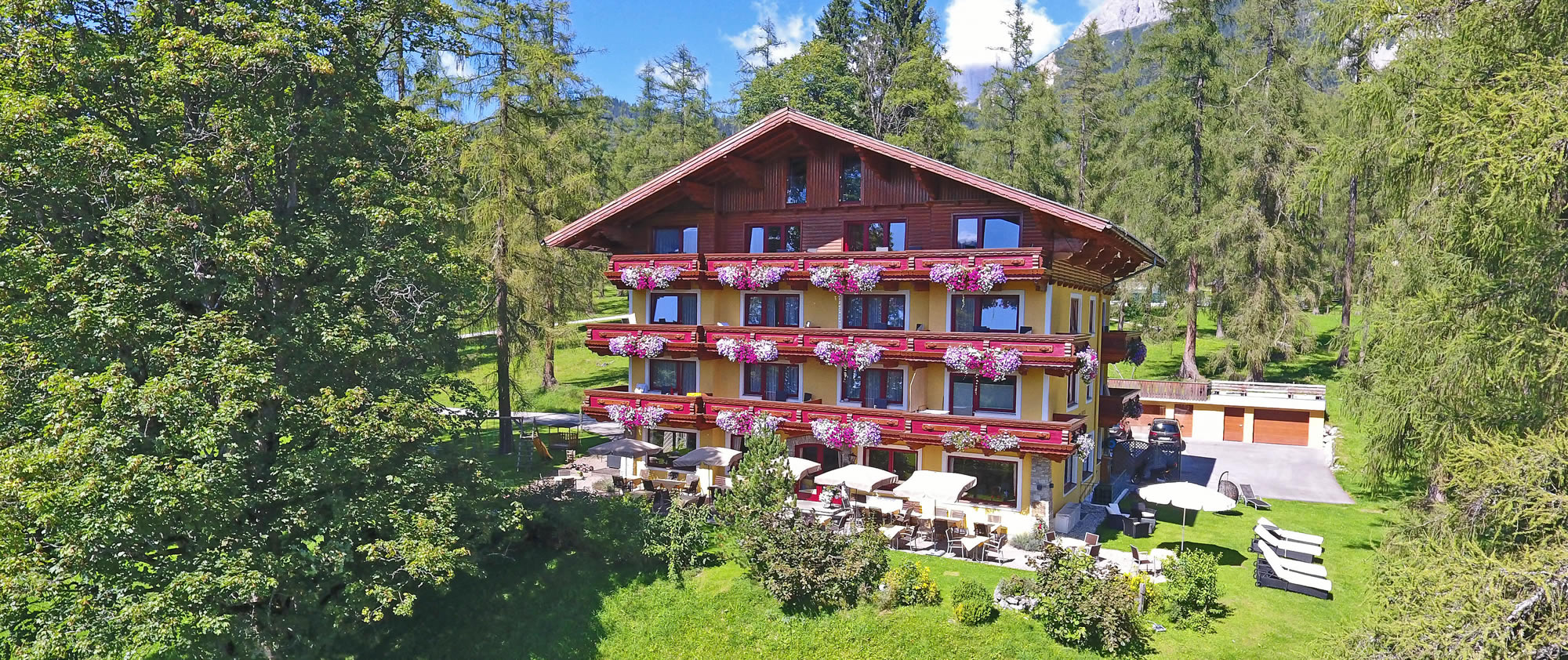 4-Sterne Hotel Rösslhof in der Ramsau, inmitten von Wiesen und Lärchenbäumen